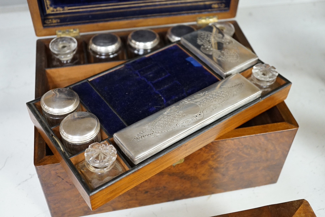 A Victorian walnut lady's toilet box with fitted interior, containing nine bottles, two glass boxes, removable sections, a hidden drawer, etc., together with two mahogany tea caddies. Condition - fair to good.